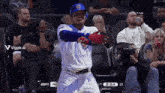 a baseball player in a chicago cubs uniform stands in front of a crowd during a game