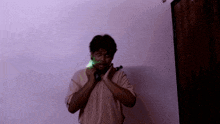 a man in a brown shirt is holding a green object