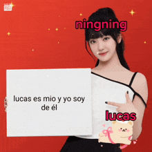 a woman holding a sign that says lucas on it