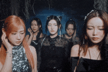 a group of young women are standing in a dark room and one of them is wearing a black top with the letter c on it