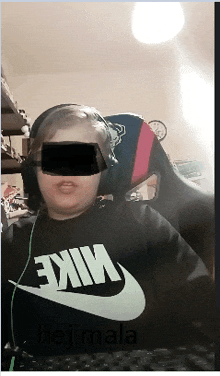 a person wearing a black nike shirt is sitting in front of a computer keyboard