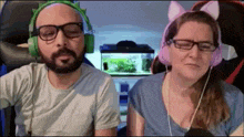 a man and a woman wearing headphones and glasses are sitting next to each other .