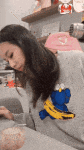 a woman is wearing a sweater with a cookie monster and a banana on it
