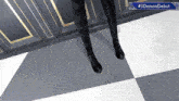 a person standing on a checkered floor next to a sign that says # 3demondebut