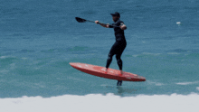 a man is riding a red surfboard that says foil