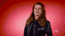 a woman in a black leather jacket with studs on the sleeves