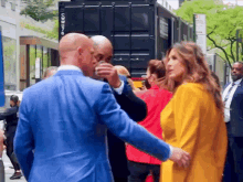 a man in a blue suit is talking to a woman in a yellow coat