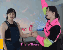two women are holding hands with the words " there there " behind them