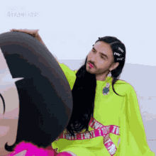 a man wearing a neon green shirt with the word twt on it