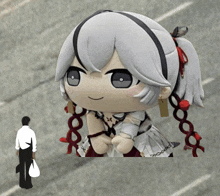 a man standing next to a giant stuffed doll with braids