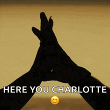 a silhouette of a person 's hands with the words here you charlotte below it