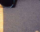 a dog is playing on a gray rug