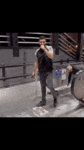 a man in a black shirt is standing in front of an escalator with a sign that says no smoking