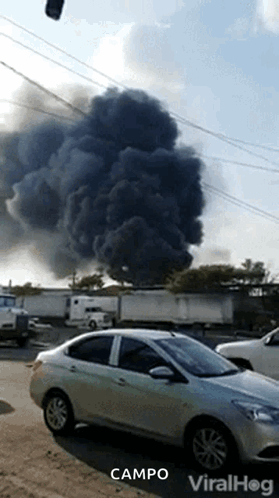 a car is parked in front of a large cloud of smoke that says campo on the bottom right