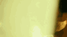 a close up of a man 's face with the sun shining through the window behind him .