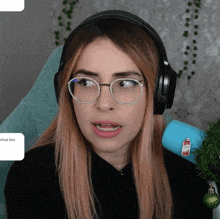 a woman wearing glasses and headphones has a sticker on her arm that says " viva los "
