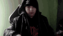 a person wearing a black jacket and a black hat with the word adidas on it