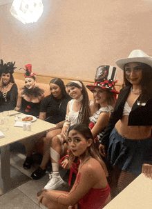 a group of women are sitting at a table with a plate of food on it