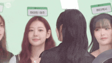 a group of young women are standing next to each other and looking at each other .