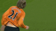 a soccer player in an orange jersey with the number 2 on it