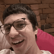a man wearing glasses is laughing with his mouth open