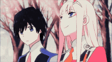 a boy and a girl are standing next to each other in a forest