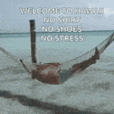 a person is laying in a hammock on a beach .