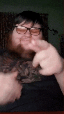 a man with glasses and a beard is pointing