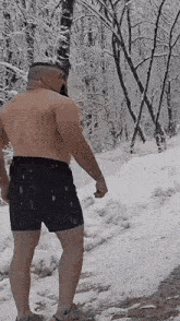 a shirtless man is standing in the snow