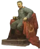 a statue of a man sitting in a chair with a red flag draped over him