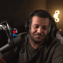 a man wearing headphones is waving his hands in front of a microphone in a dark room