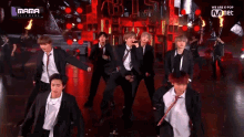 a group of men in suits and ties are dancing on a stage with the words mama on the bottom right