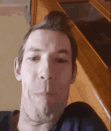 a close up of a man 's face with a wooden counter in the background