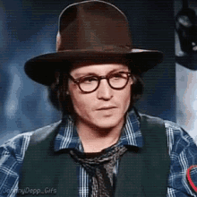 johnny depp is wearing a hat and glasses and a plaid shirt and tie .
