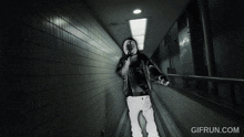 a black and white photo of a man in a hallway with the website gifrun.com in the bottom right corner