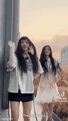 a couple of girls are standing next to each other and dancing .