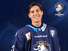 a hockey player wearing a jersey that says bauer is pointing at the camera