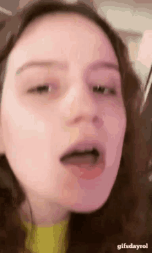 a close up of a woman 's face with her mouth open and the words gifsdayrol at the bottom