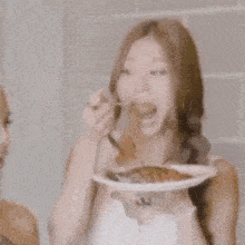 a woman is holding a plate of food with a fork in her hand .