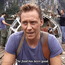 a man wearing a purple shirt that says the food has been good