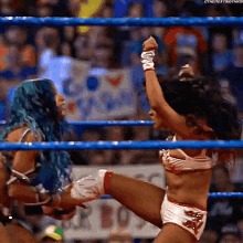 a female wrestler kicking another wrestler 's leg in a wrestling ring .