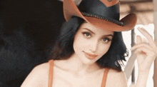 a woman is wearing a cowboy hat and a brown bra