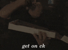a person holding a box that says " get on ck " on it
