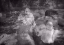 a black and white photo of a group of people swimming in a river .