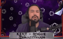 a man wearing headphones stands in front of a microphone and says kent rogue