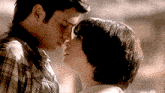 a man and a woman are touching their foreheads