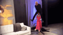 a woman in a red dress is standing on a man 's feet