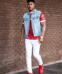 a man wearing a denim vest and a red shirt that says coca cola