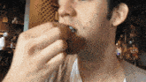 a man in a white shirt is eating a hamburger