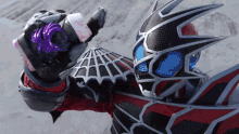 a person in a spider web costume is holding a purple object in their hand